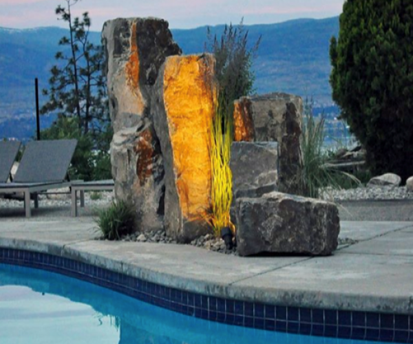 beautiful lit up rock sculpture beside pool
