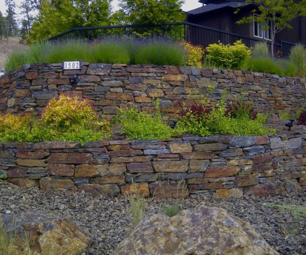 several tiers of curved rock walls with plants